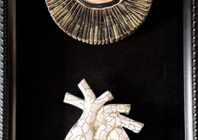 Healing Hearths, 2024, 8.5x20", Carved wood, acrylics, gold ink, wax on wooden canvas. Price: $450 Artist's description: This piece represents being a witness to helping others rebuild and put their hearts back together.