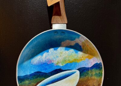Over the Easy Planes VII, 2025, 12x8.5”, acrylics on decommissioned frying pan. Price: $250 Artist’s description: These whimsical pieces are a tribute to the hardworking cooks out there, recognizing their craft as fine art. It is also a tribute to all the used and abused frying pans in the world!